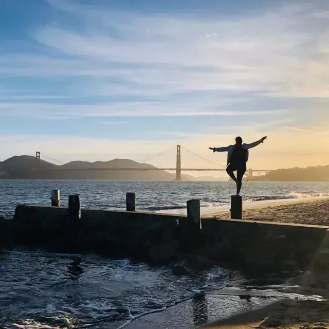 Uma mulher está em um píer no bairro de Marina, em São Francisco, olhando para a Ponte Golden Gate.